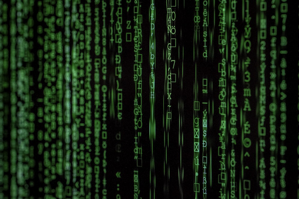 Streams of code on a dark terminal screen representing threat detection and log analysis
